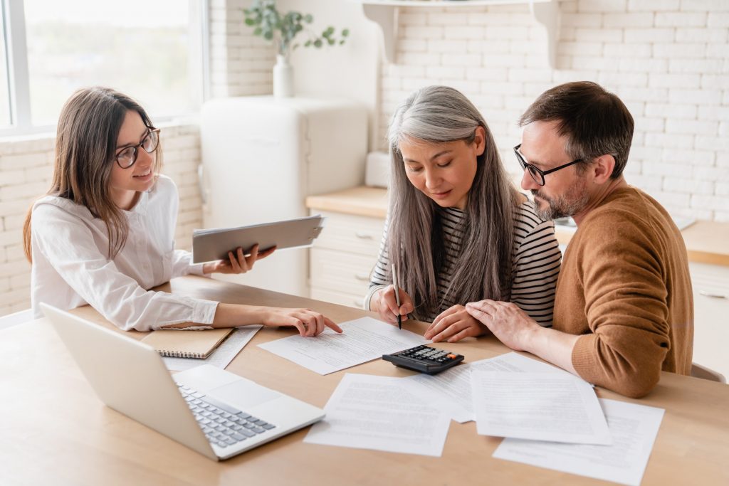 Insurance agent consulting mature family couple, discussing health insurance, signing contract deal