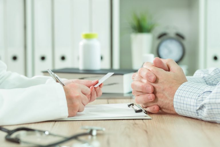 Doctor taking medical insurance card from patient