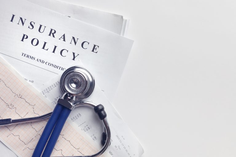 Insurance Policy Terms & Conditions Next to a Stethoscope