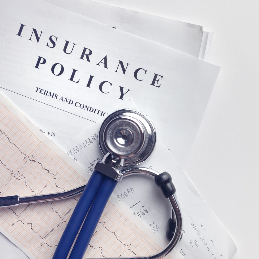 Insurance Policy Terms & Conditions Next to a Stethoscope